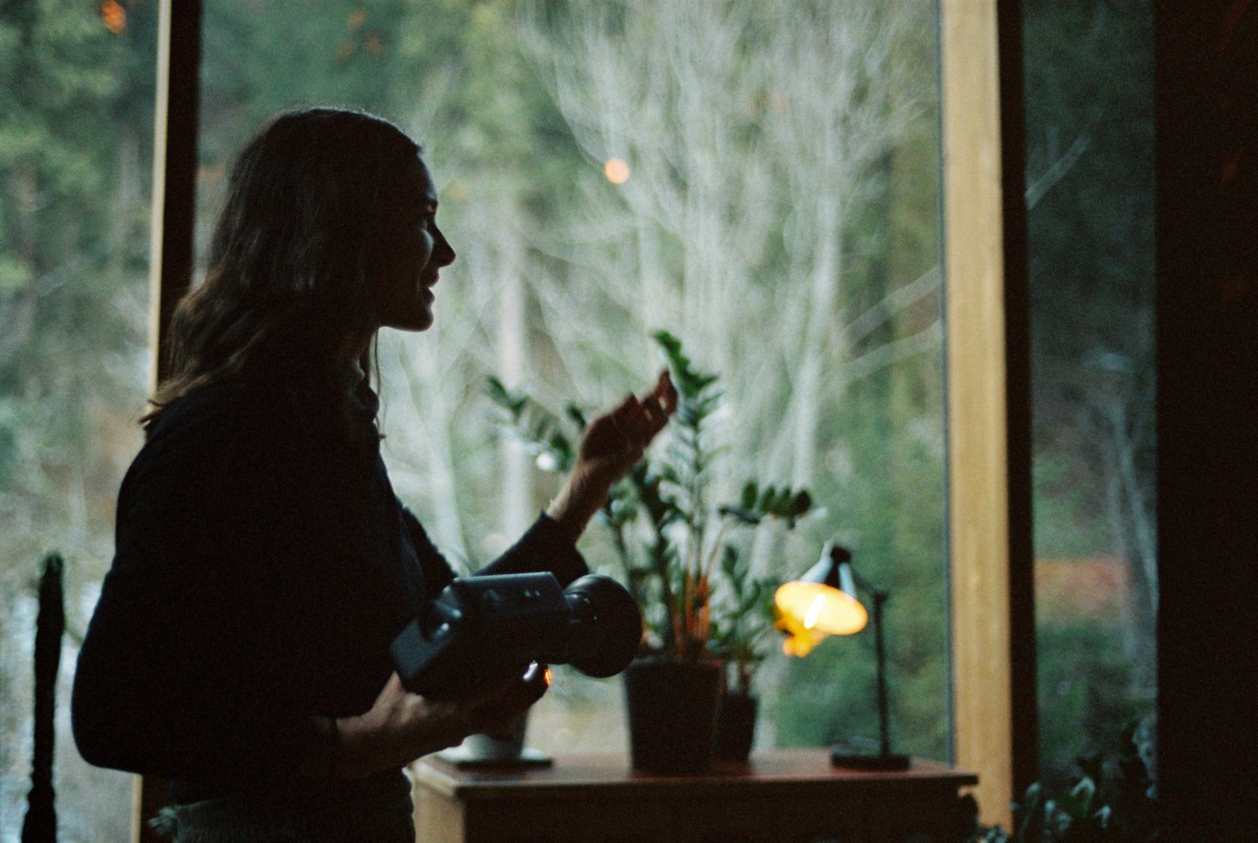 Irene Schweizer am Fenster, mit Filmkamera in der Hand