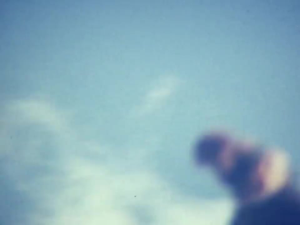 Filmstill aus Norda 001A: verwischte Läuferin vor blauem Himmel