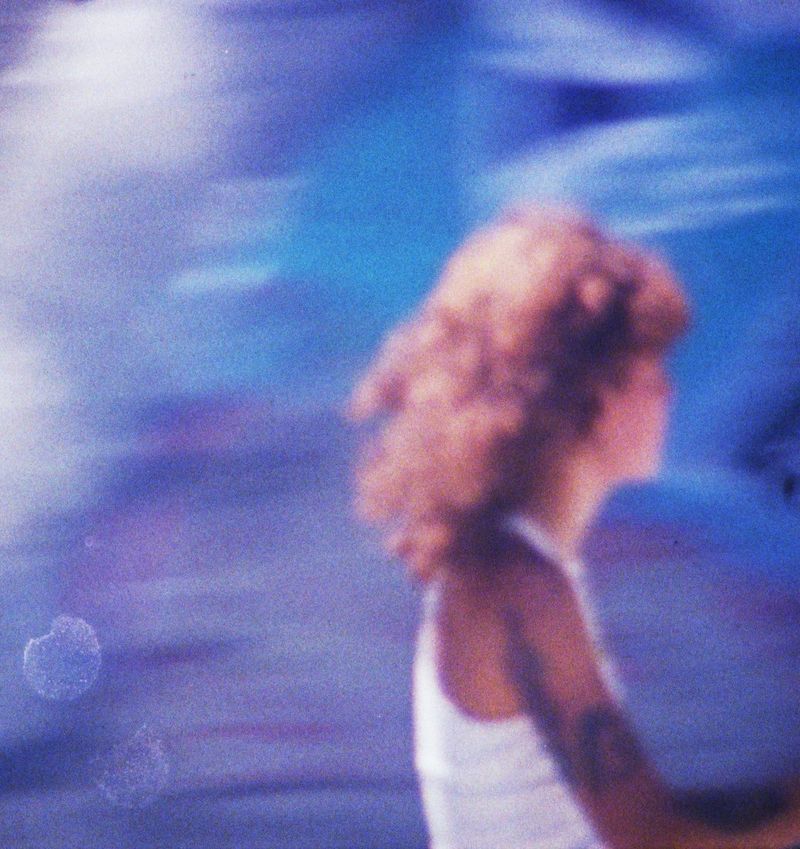 Fine Art Print: Frau mit roten Locken von hinten vor blauem Himmel