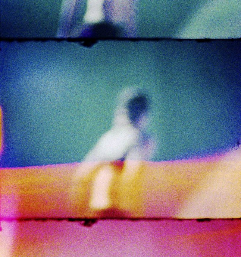 Fine Art Print: Verwischte Figur vor Graublau mit oranger Lichtbahn